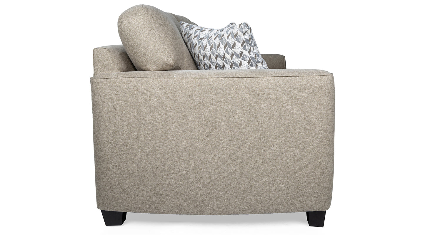 Beige sofa with a patterned pillow on a white background