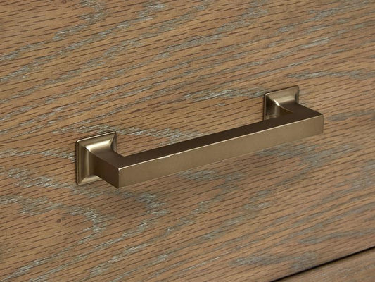 Gold cabinet handle on a wooden surface