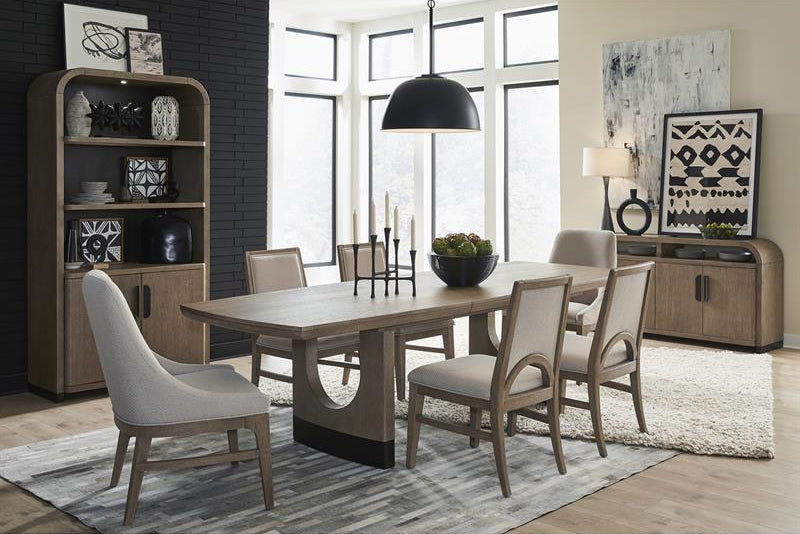 Dining room with wooden table and chairs, bookshelf, and large windows.