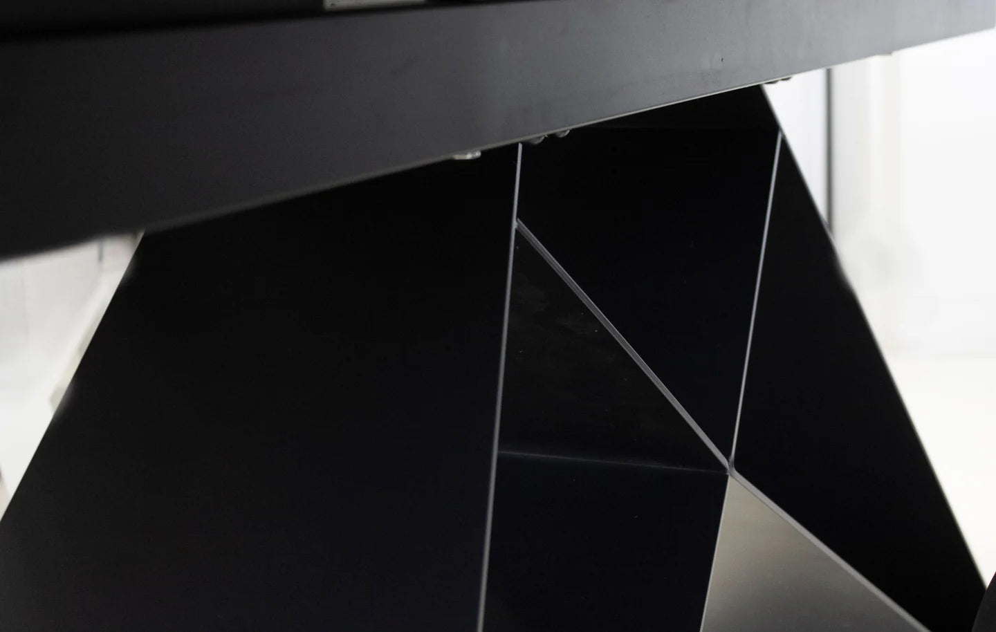 Close-up of a black metal table base with geometric design