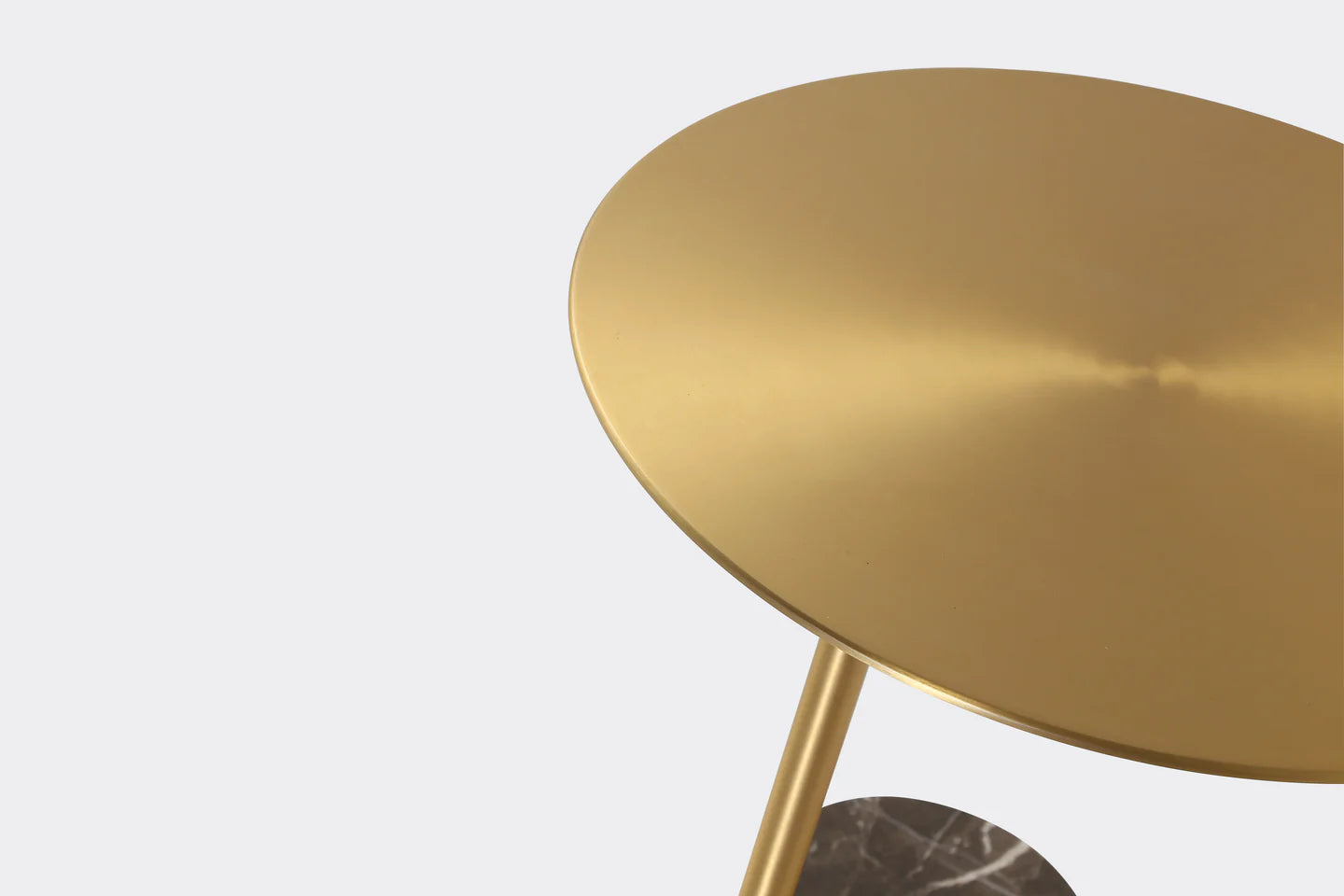 Gold round table with marble base on a light gray background