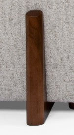 Wooden furniture leg on a textured fabric surface