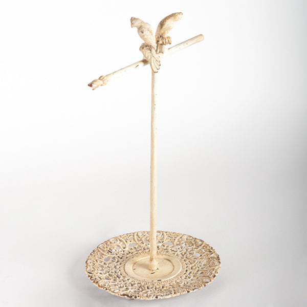 Gold jewelry stand with decorative base on a white background