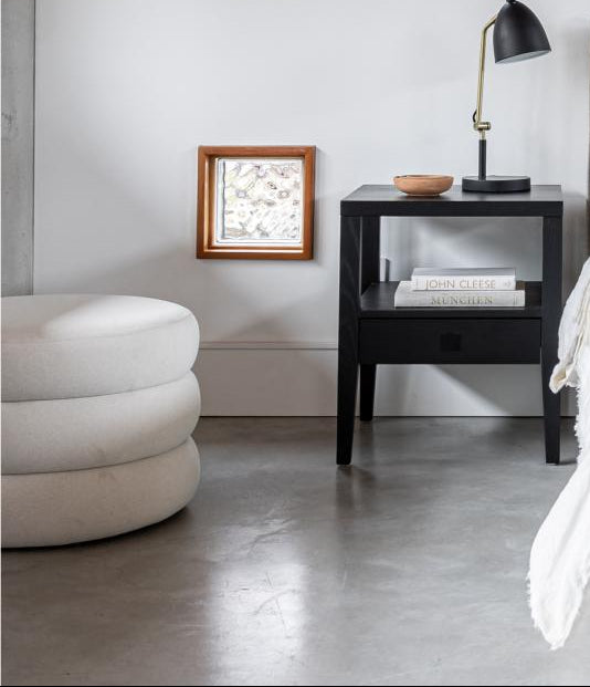 Modern bedroom with a bed, nightstand, and wall art.