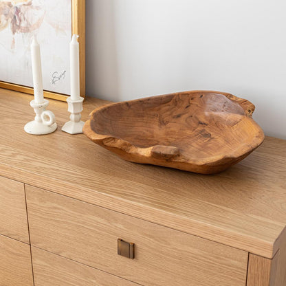 Wooden bowl on a wooden surface with candles in the background