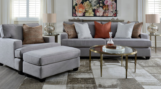 Gray sectional sofa with patterned cushions in a living room setting.