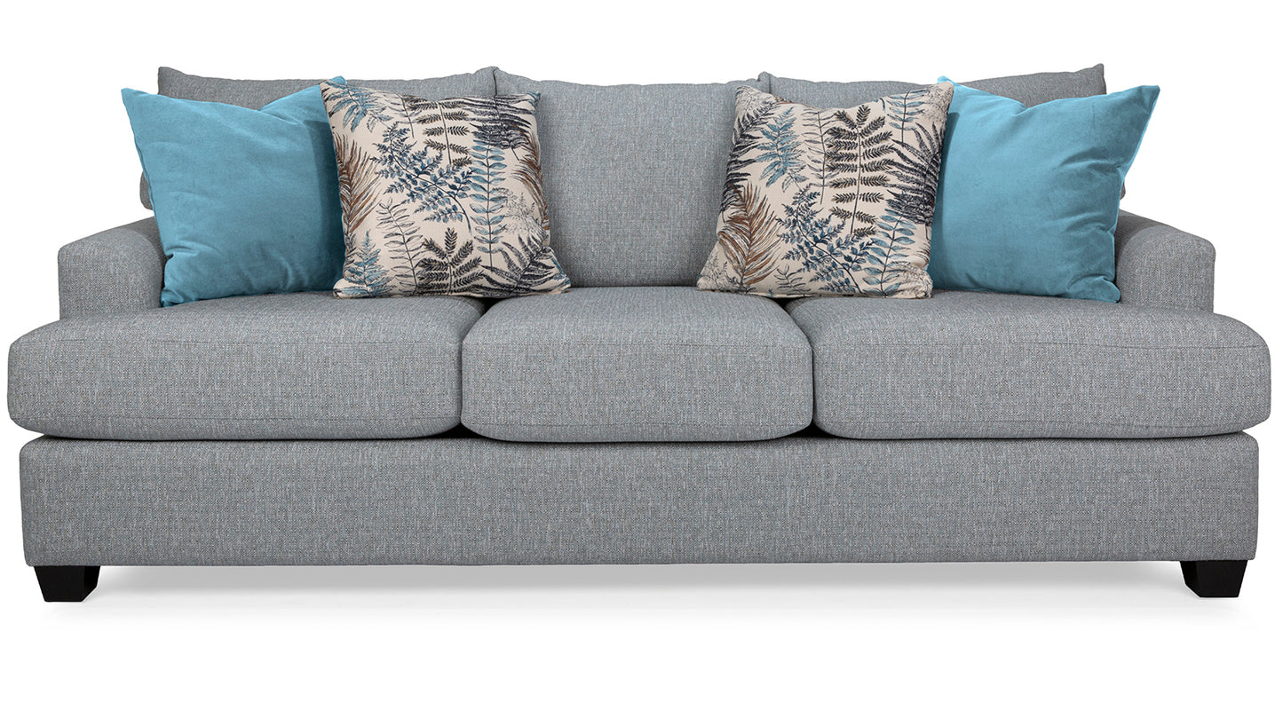Gray sofa with blue and patterned cushions on a white background