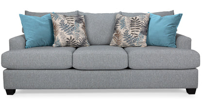 Gray sofa with blue and patterned cushions on a white background