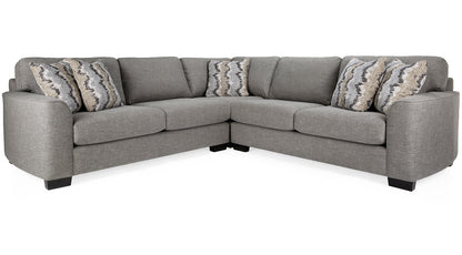 Gray sectional sofa with patterned cushions on a white background