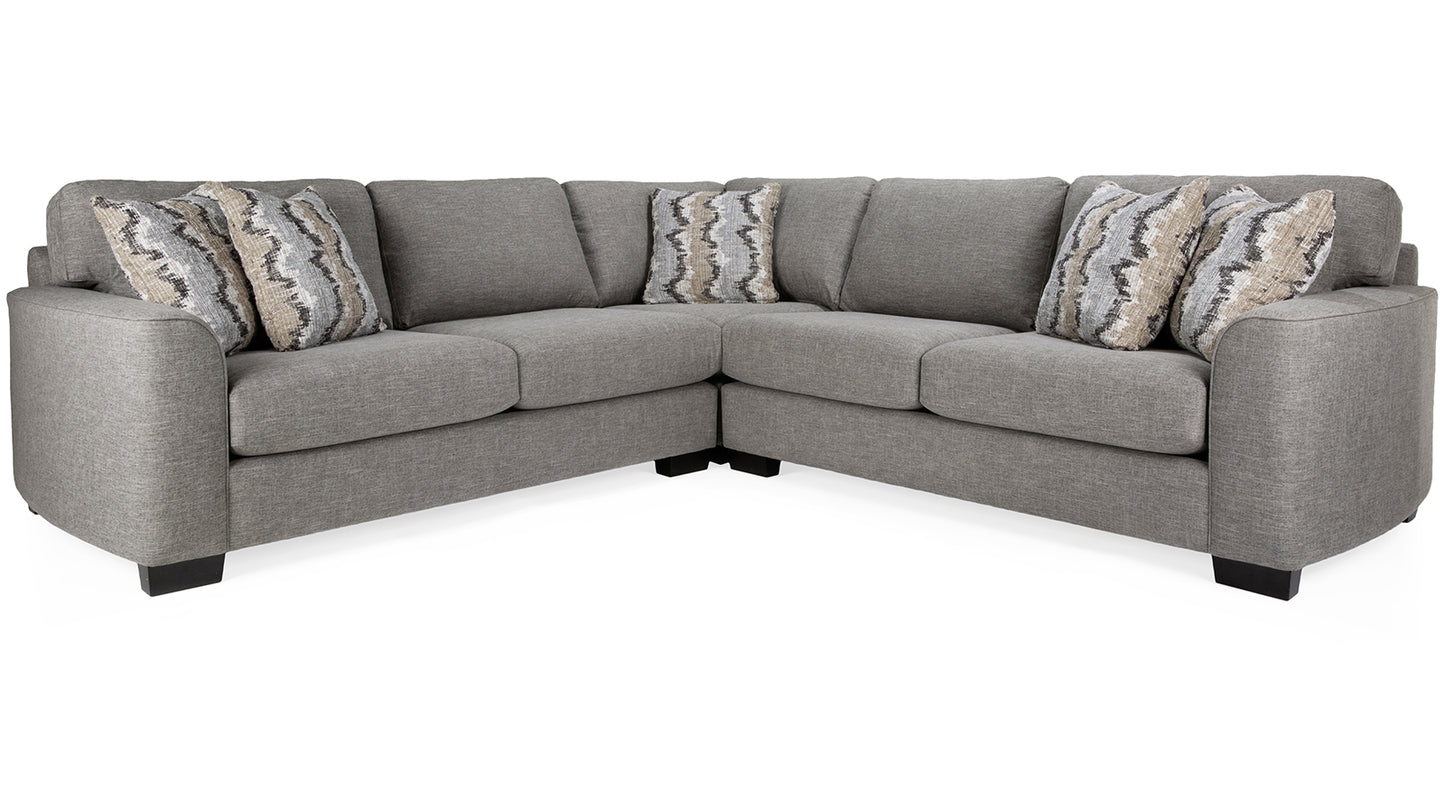 Gray sectional sofa with patterned cushions on a white background