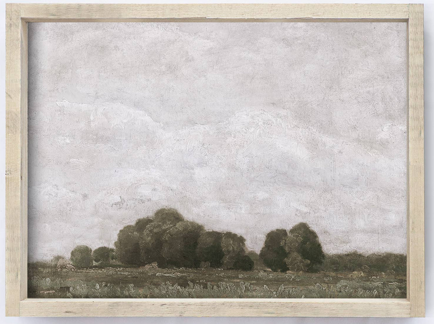 Framed landscape print with trees and a field on a white wall