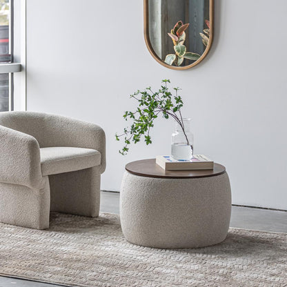 Modern living room with a beige armchair and round ottoman table.