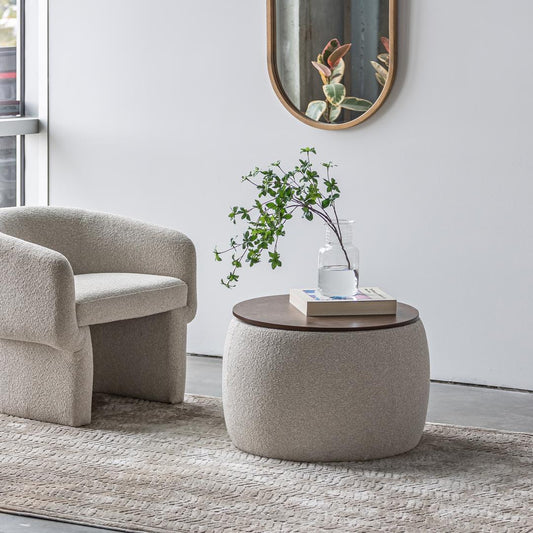 Modern living room with a beige armchair and round ottoman table.