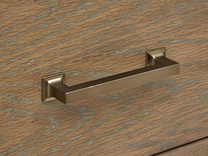 Gold cabinet handle on a wooden surface