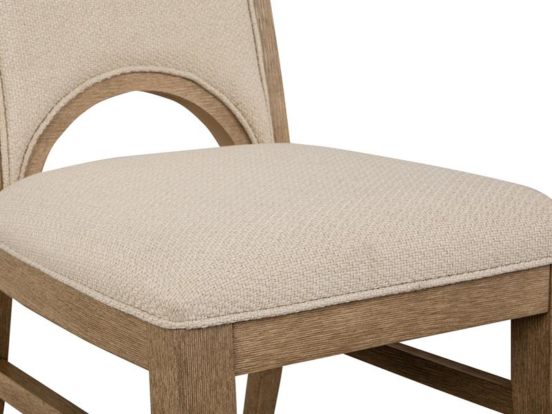 Beige upholstered chair with wooden frame on a white background