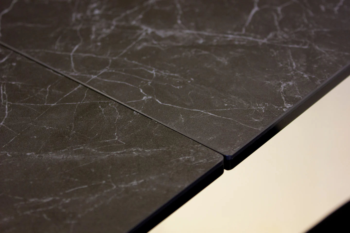 Close-up of dark marble tiles with a light-colored grout line.