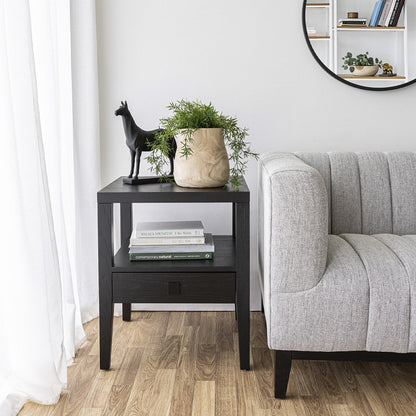 Living room with a black side table, gray sofa, and decorative items.