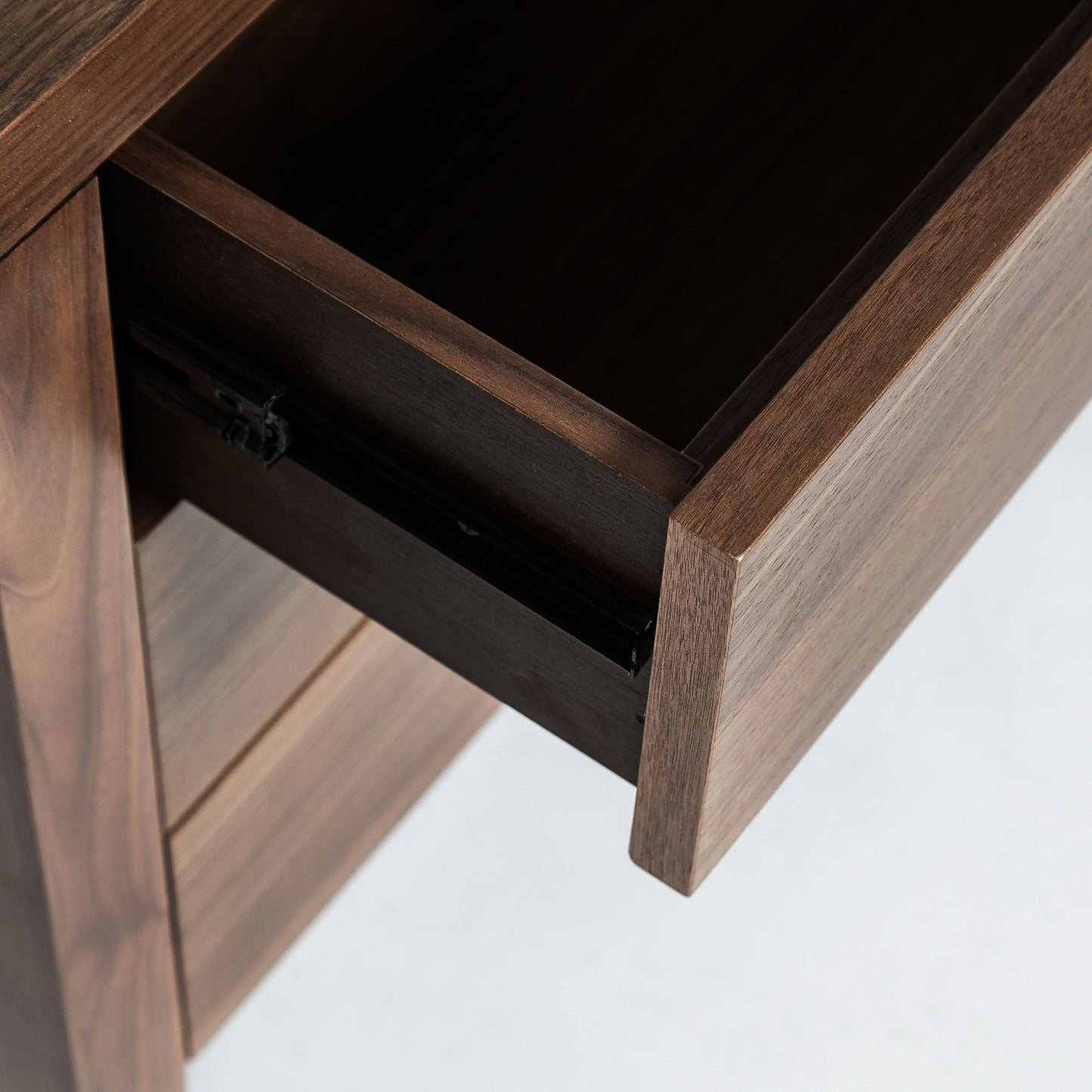 Wooden desk with an open drawer on a white background