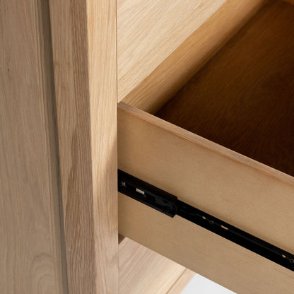 Close-up of a wooden drawer with a black metal handle.