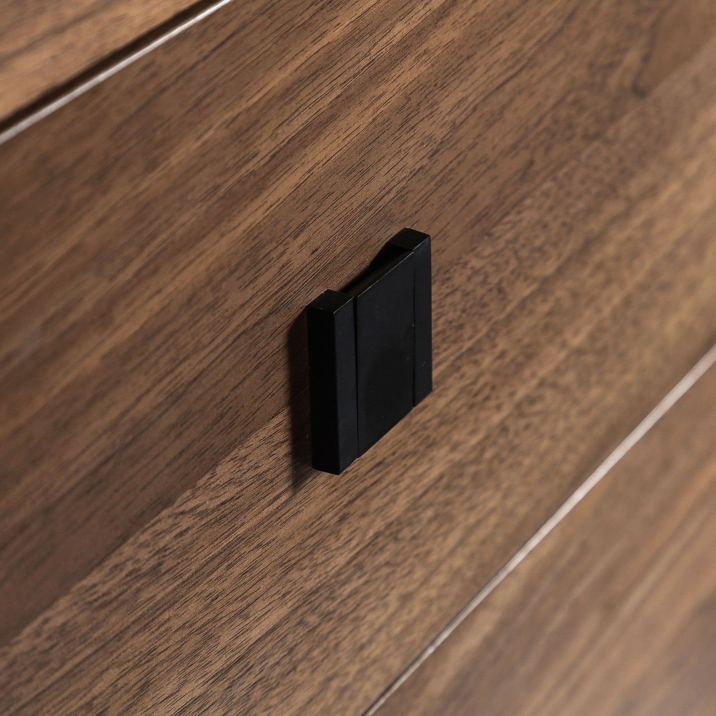 Close-up of a wooden drawer with a black handle