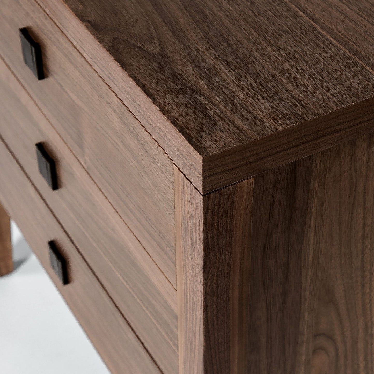 Close-up of a wooden dresser with dark brown finish