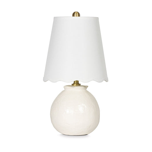 White table lamp with a scalloped white shade on a white background