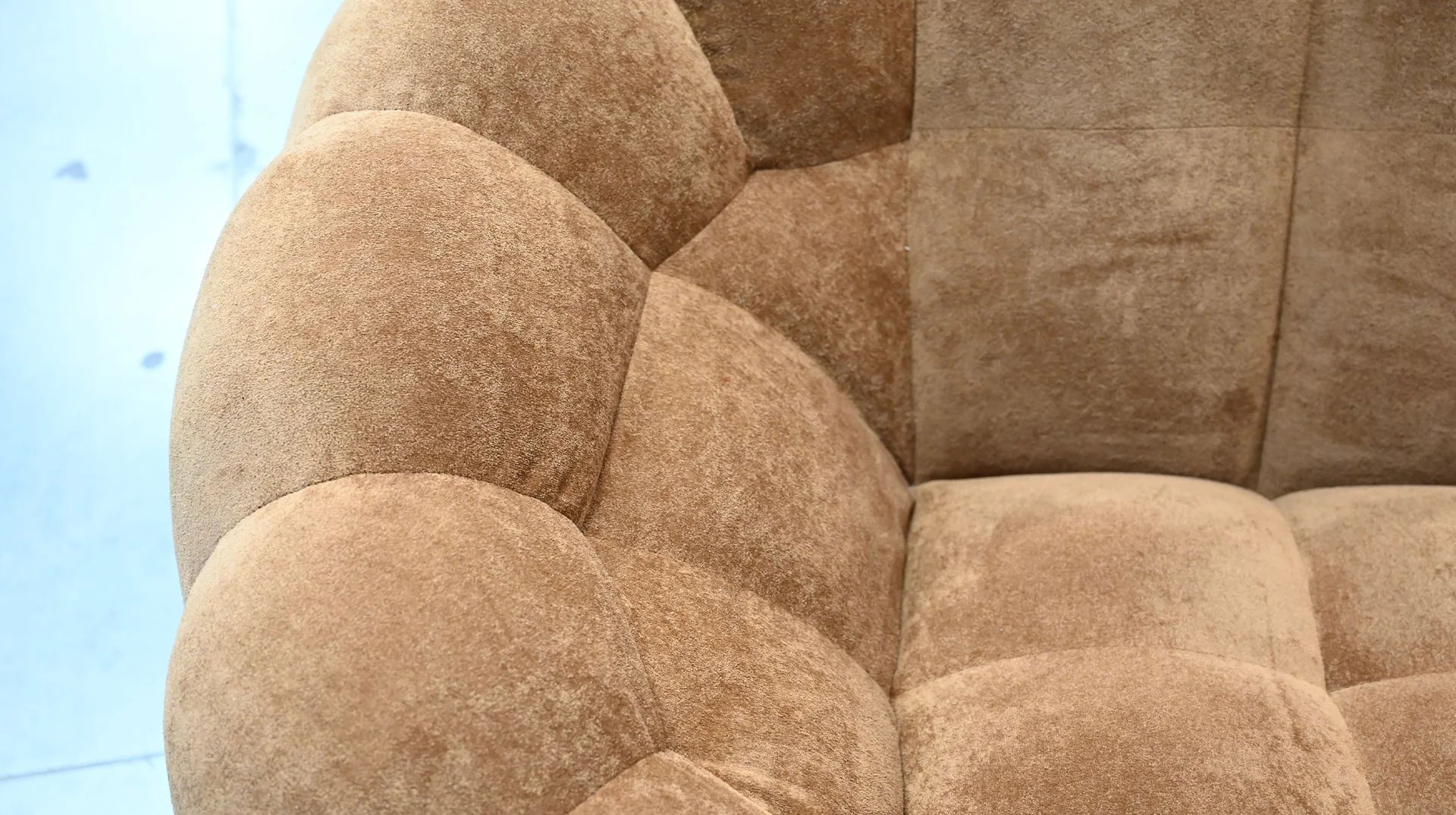 Close-up of a textured brown sofa with a blurred background