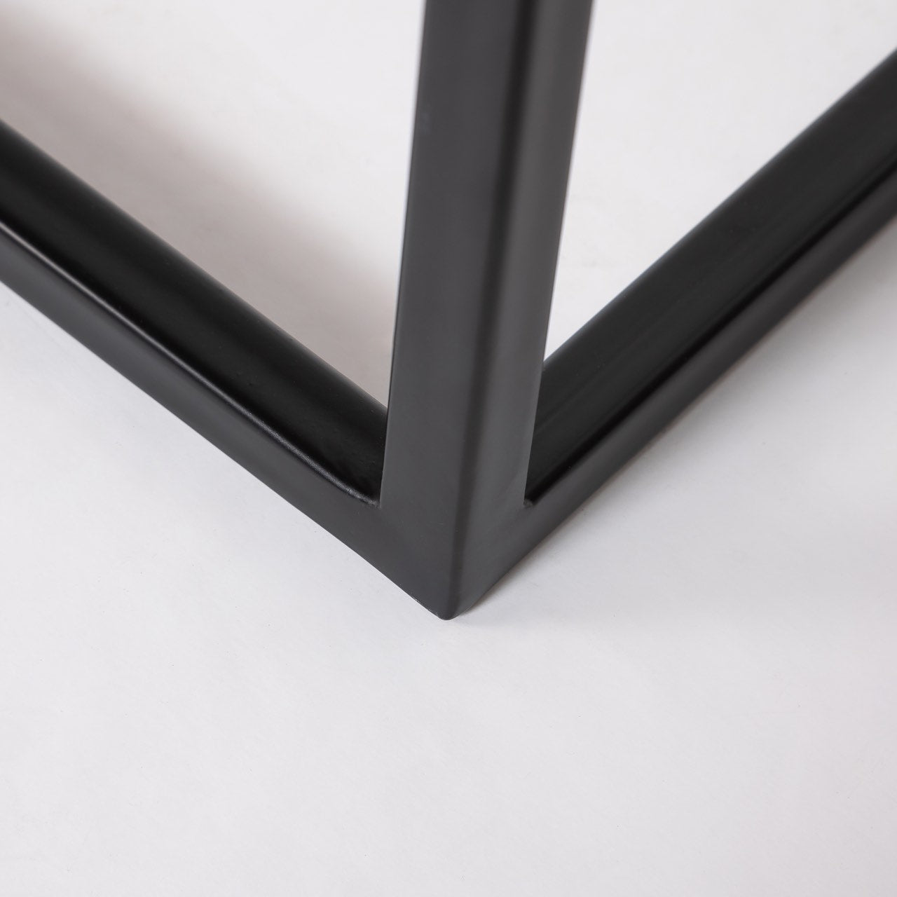Close-up of a black metal frame on a light gray background