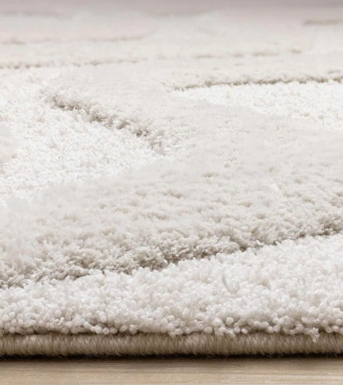 Close-up of a textured white rug on a wooden floor