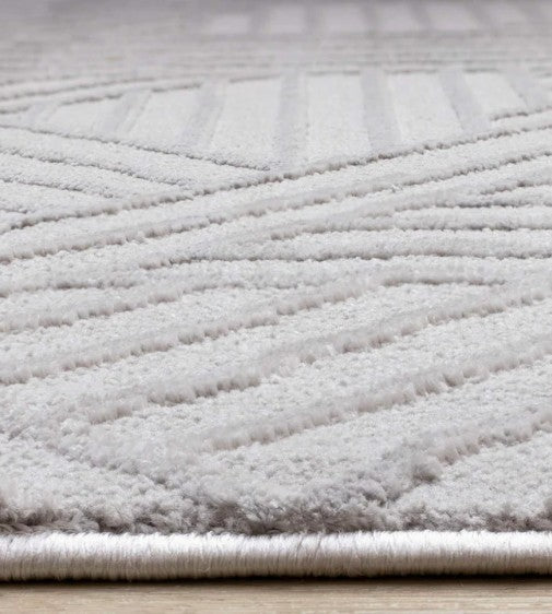 Close-up of a textured gray rug on a wooden floor