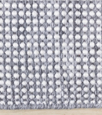 Textured fabric with a pattern of small white dots on a gray background