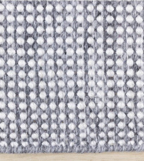 Textured fabric with a pattern of small white dots on a gray background