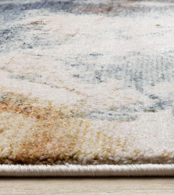 Close-up of a textured area rug with neutral colors on a wooden floor.