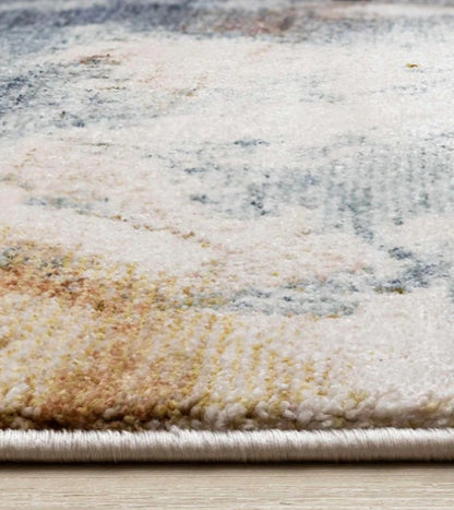 Close-up of a textured area rug with neutral colors on a wooden floor.
