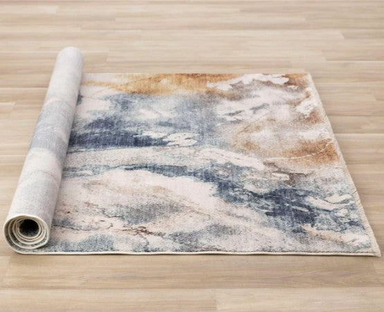 Roll of abstract patterned rug on a wooden floor