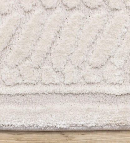Close-up of a textured beige rug on a wooden floor