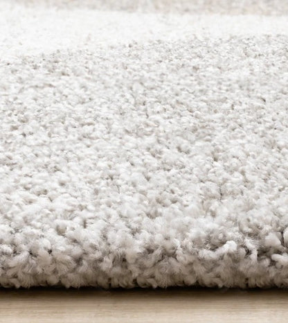 Close-up of a textured white rug on a wooden floor