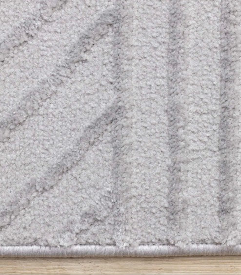 Close-up of a textured gray rug on a wooden floor