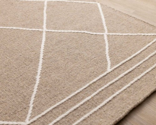 Beige rug with white geometric lines on a wooden floor