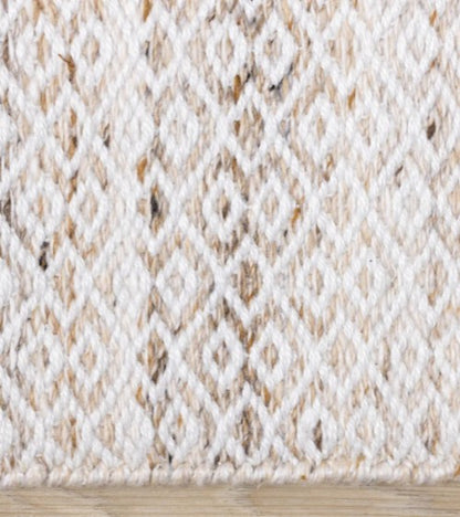 Close-up of a textured beige and white fabric with a diamond pattern.