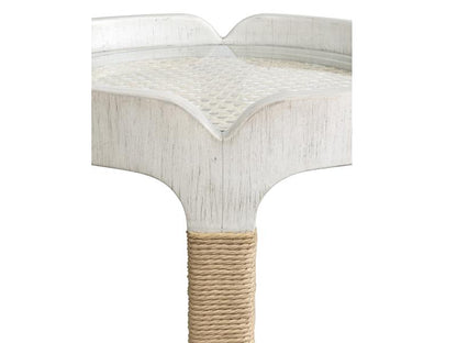 Round white table with a textured surface and woven base on a white background