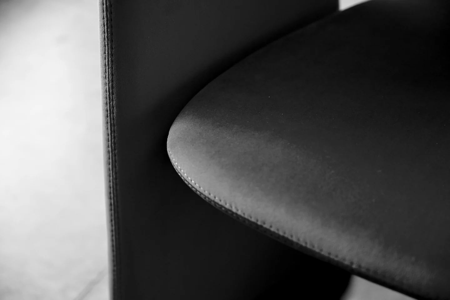Close-up of a black velvet chair with visible stitching