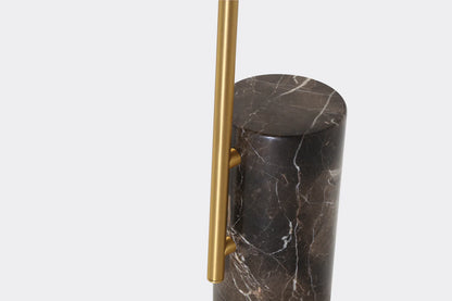 Marble cylindrical object with a gold handle on a light gray background