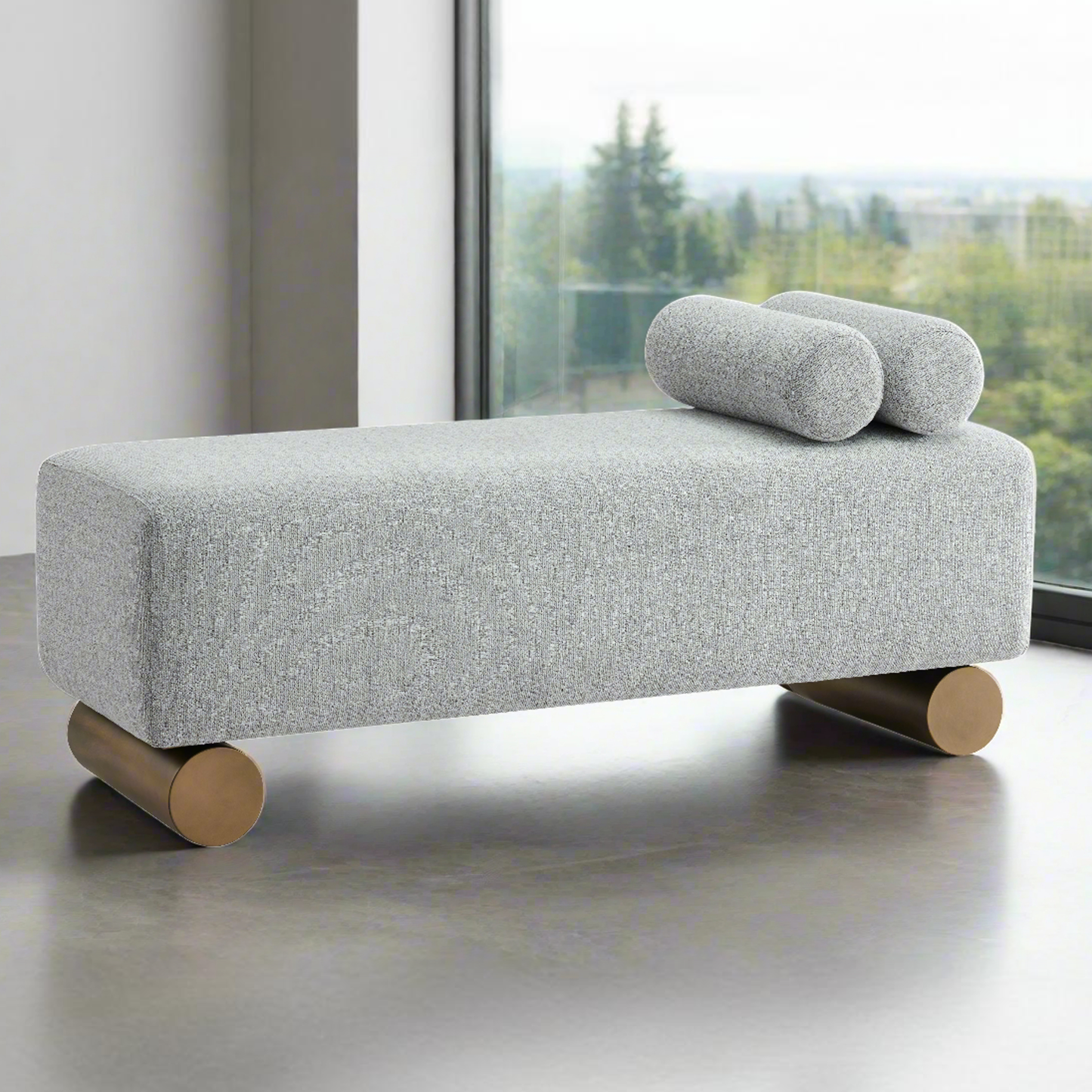Gray upholstered bench with wooden legs and cylindrical cushions in a modern interior setting.