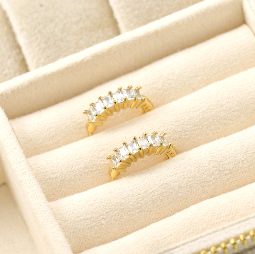 Gold rings with gemstones on a beige jewelry tray