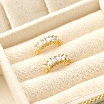 Gold rings with gemstones on a beige jewelry tray