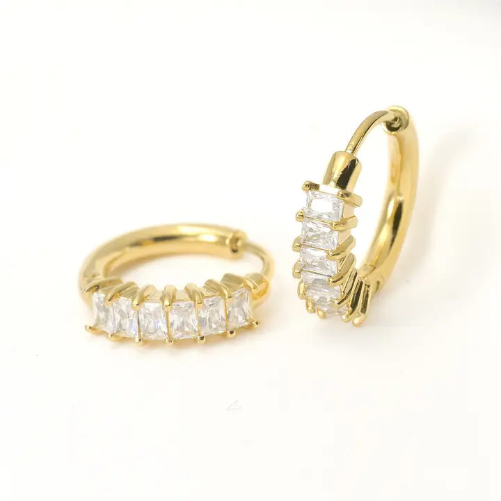 Gold hoop earrings with clear gemstones on a white background