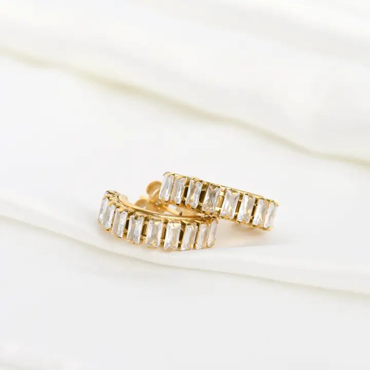 Gold hoop earrings with clear gemstones on a white background