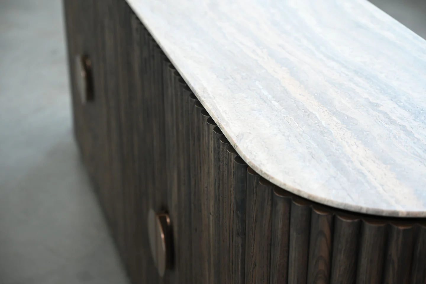 Wooden sideboard with marble countertop on a gray floor