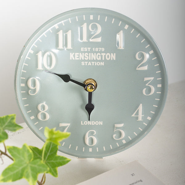 Wall clock with 'Kensington Station' branding on a light background